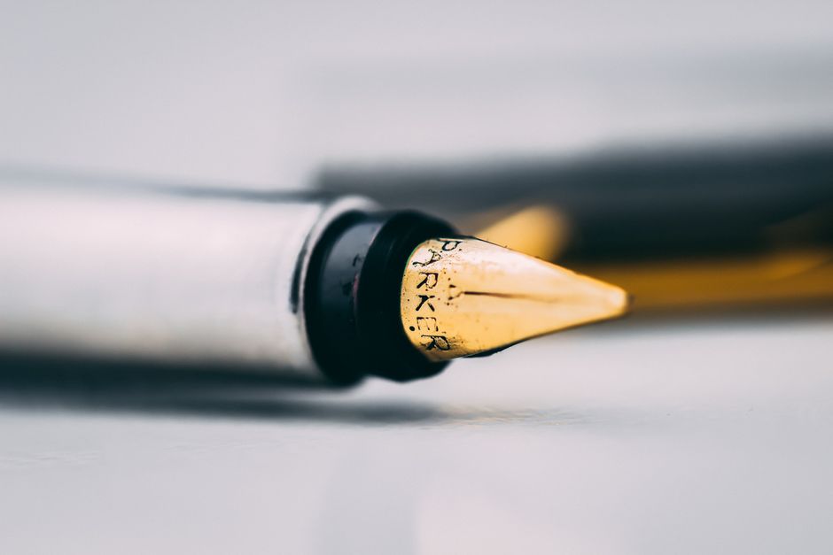 Metal fountain pen on wooden desk